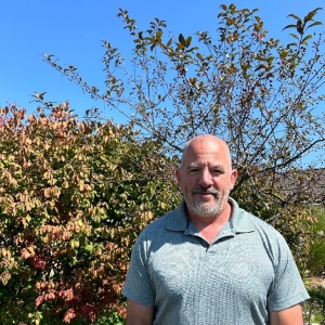 John, our client services coordinator, stands by trees at FROM.